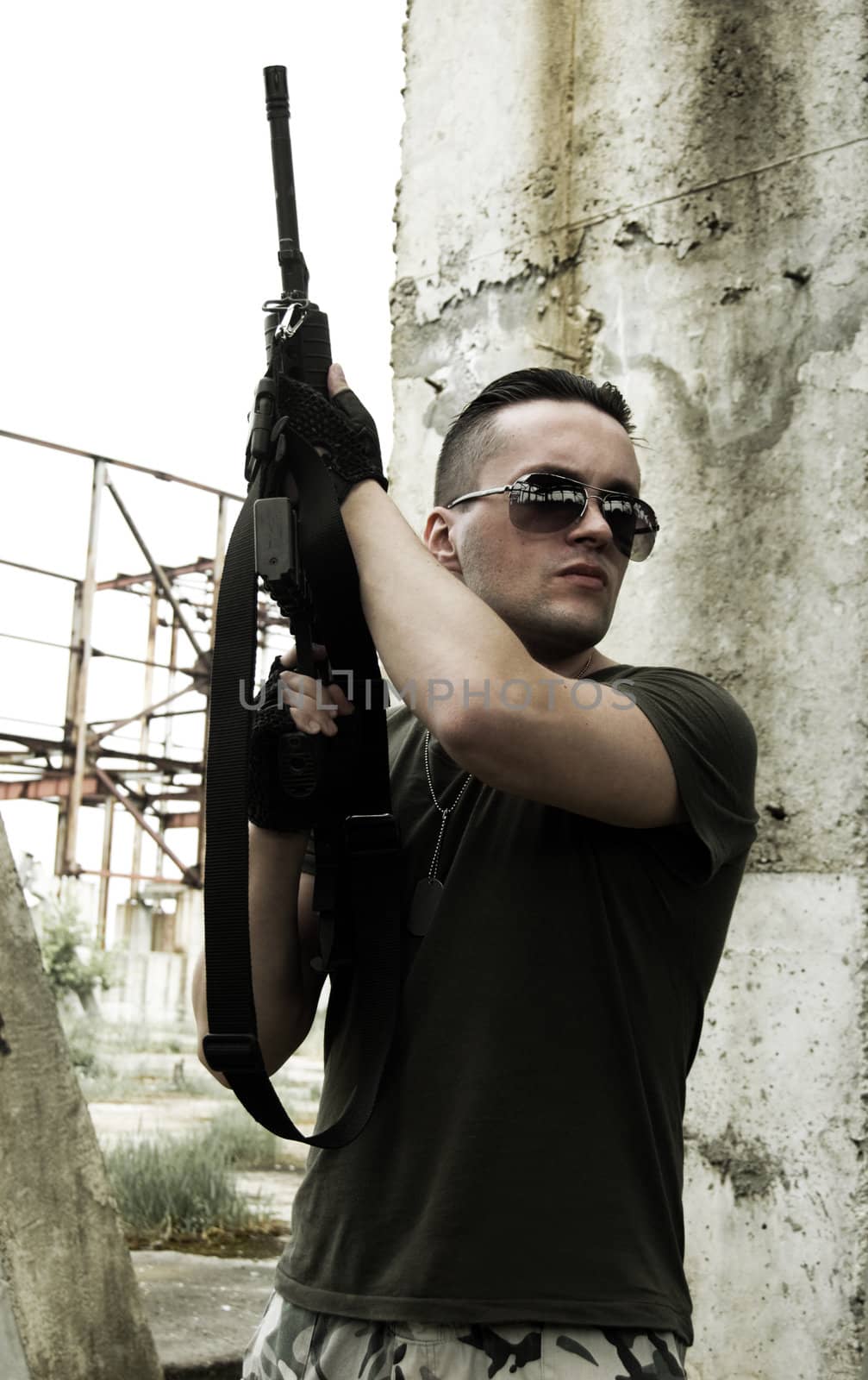 Soldier in camouflage and glasses with the gun up