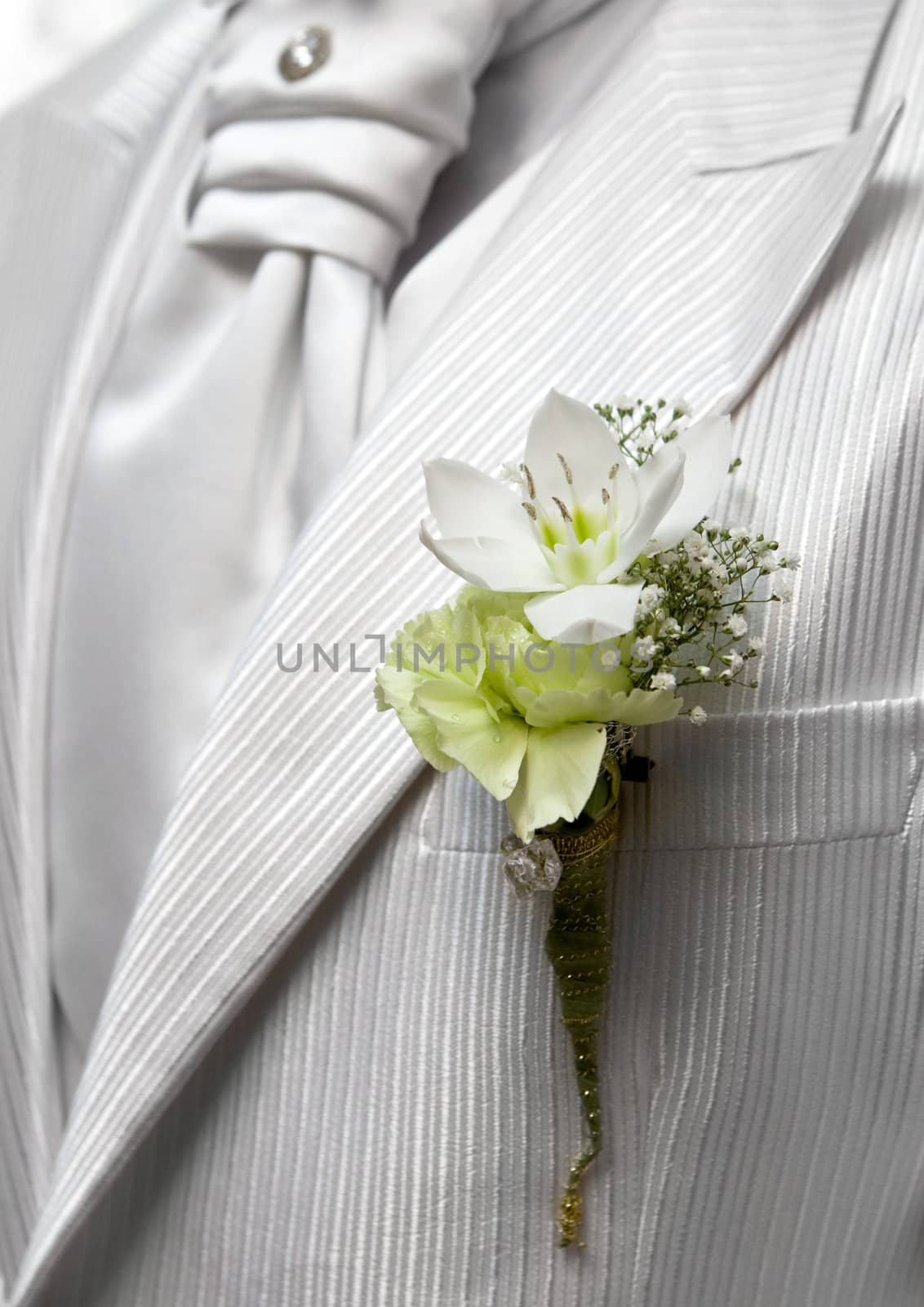 Closeup shot of flower in buttonhole. Groom suit