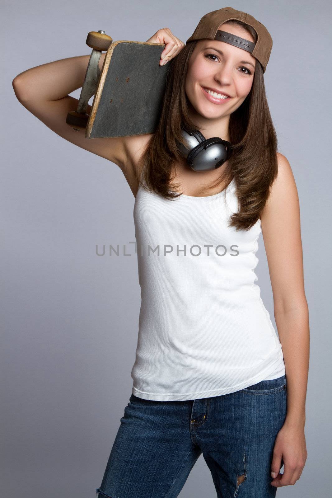 Smiling skater girl holding skateboard