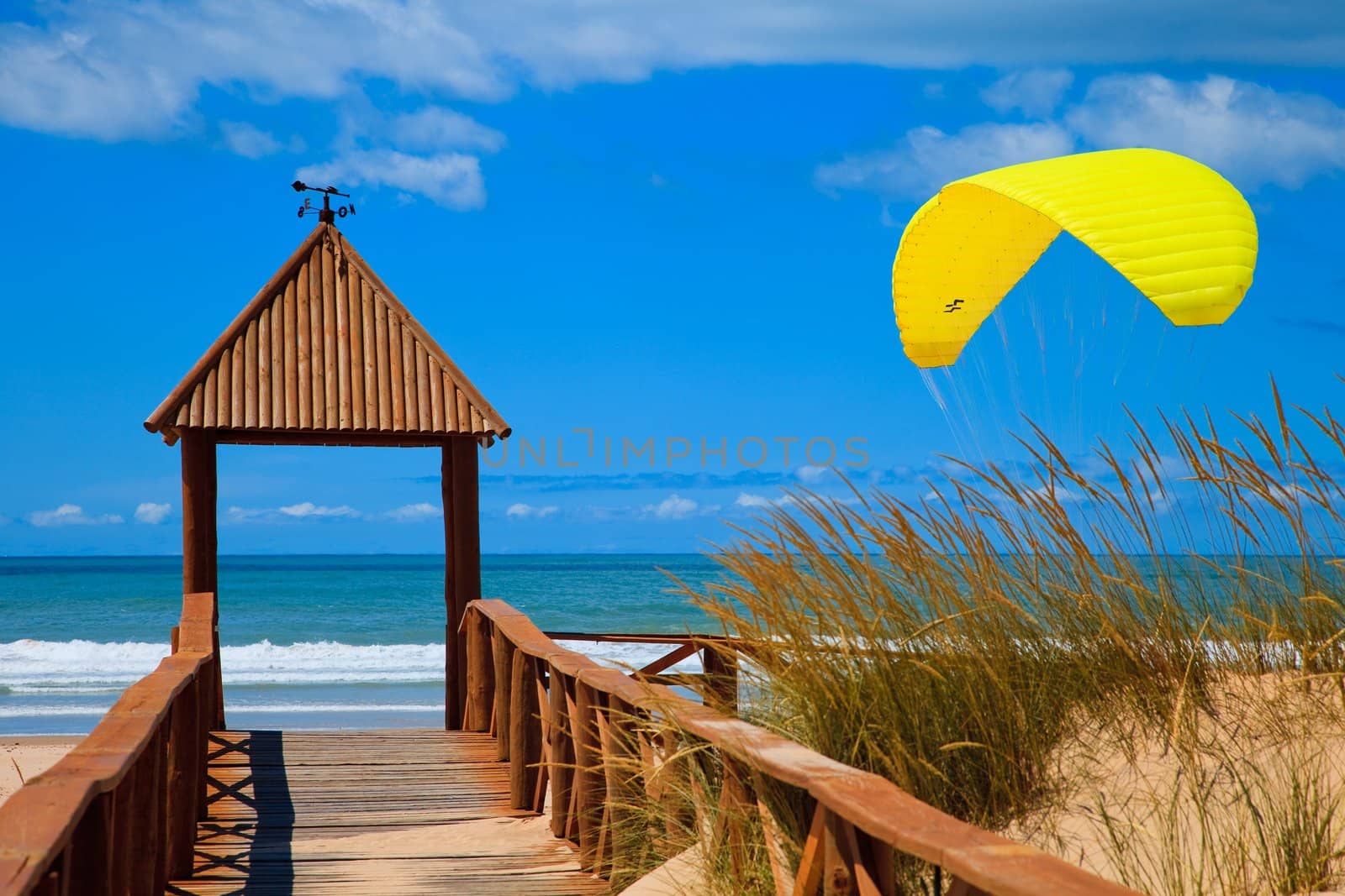 Footbridge of access to Cortadura's beach in Cádiz and paraglider