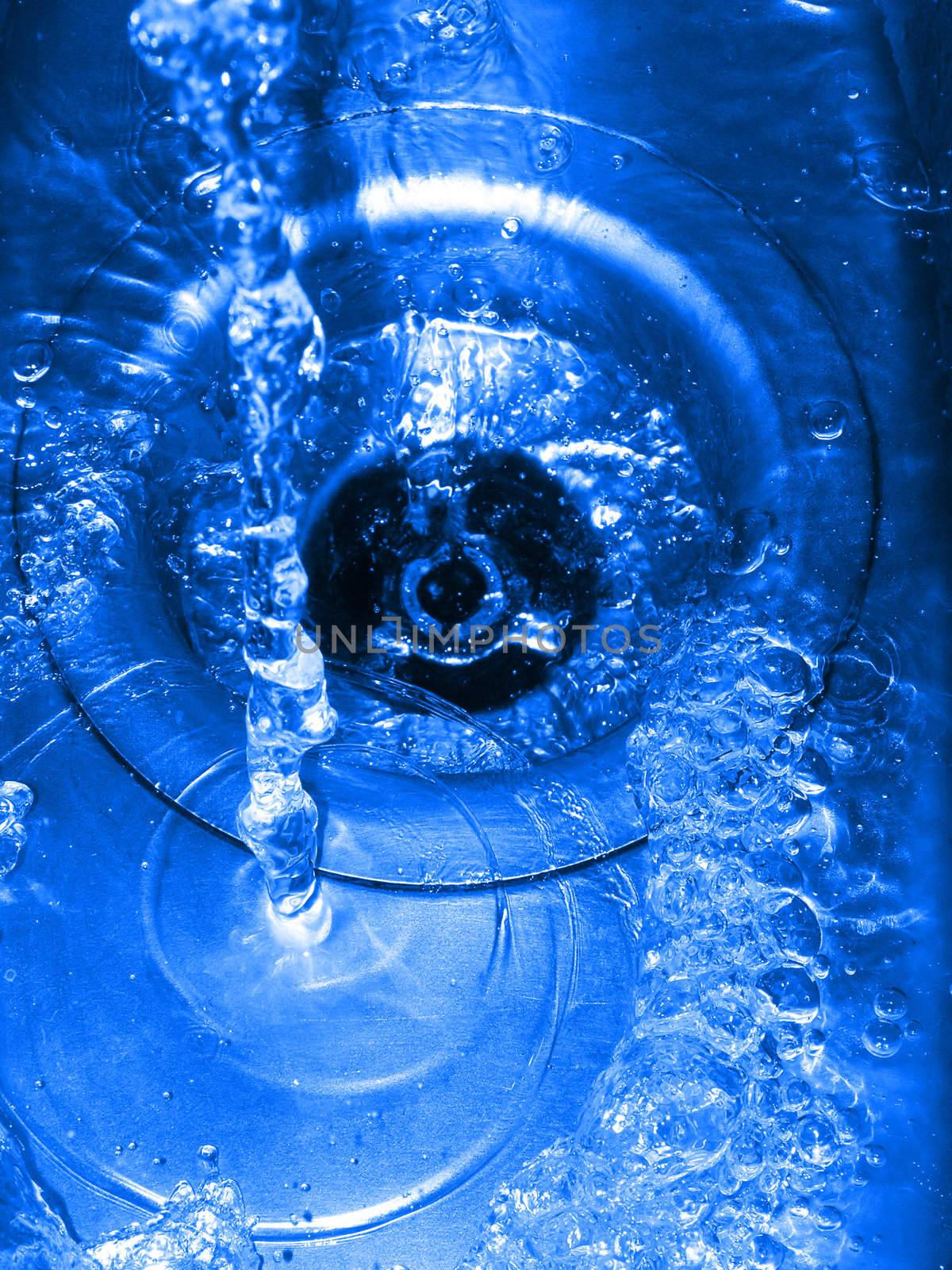 blue cast water going down a plughole or drain