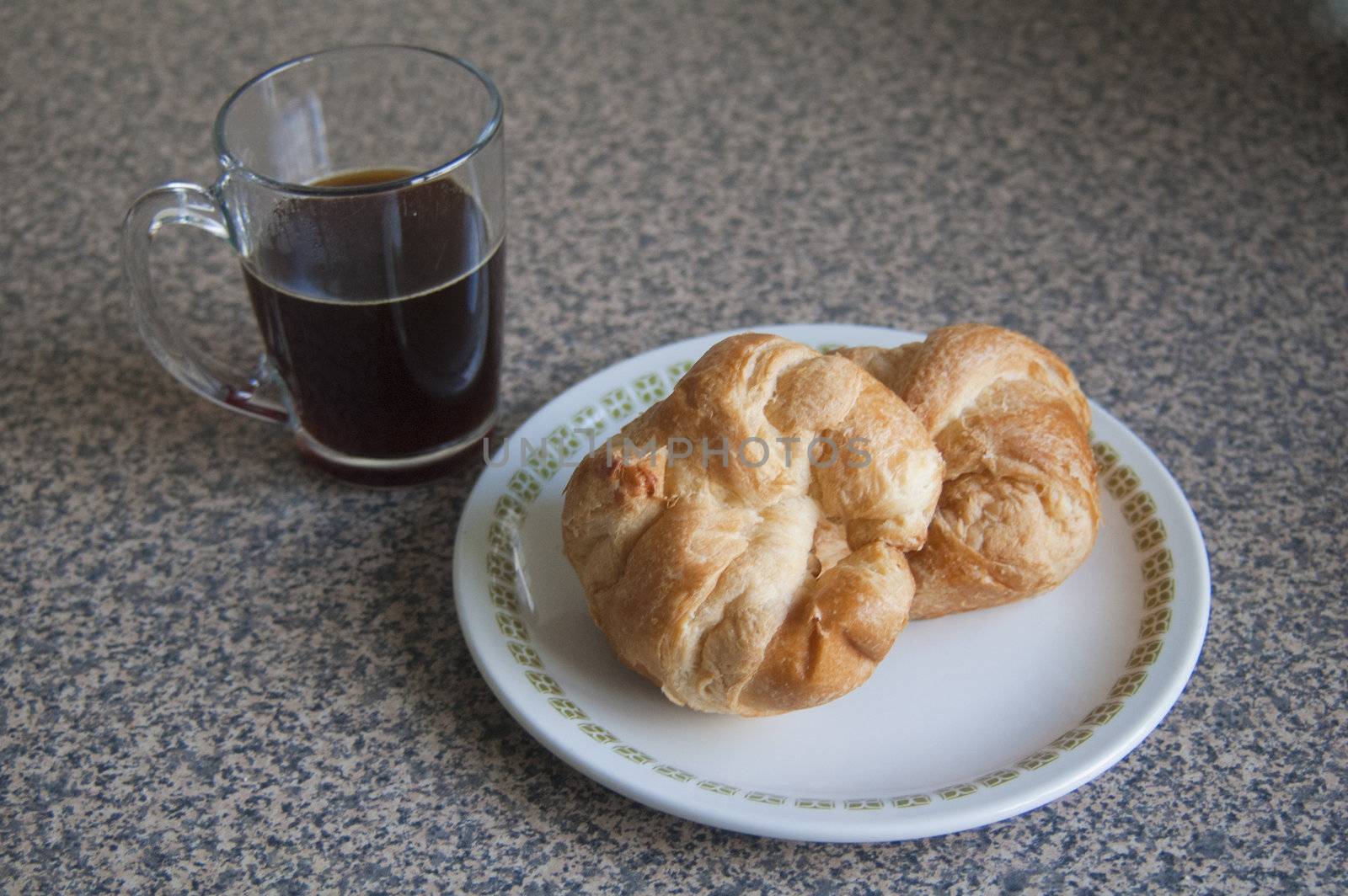 Coffee and two croissants on a plate