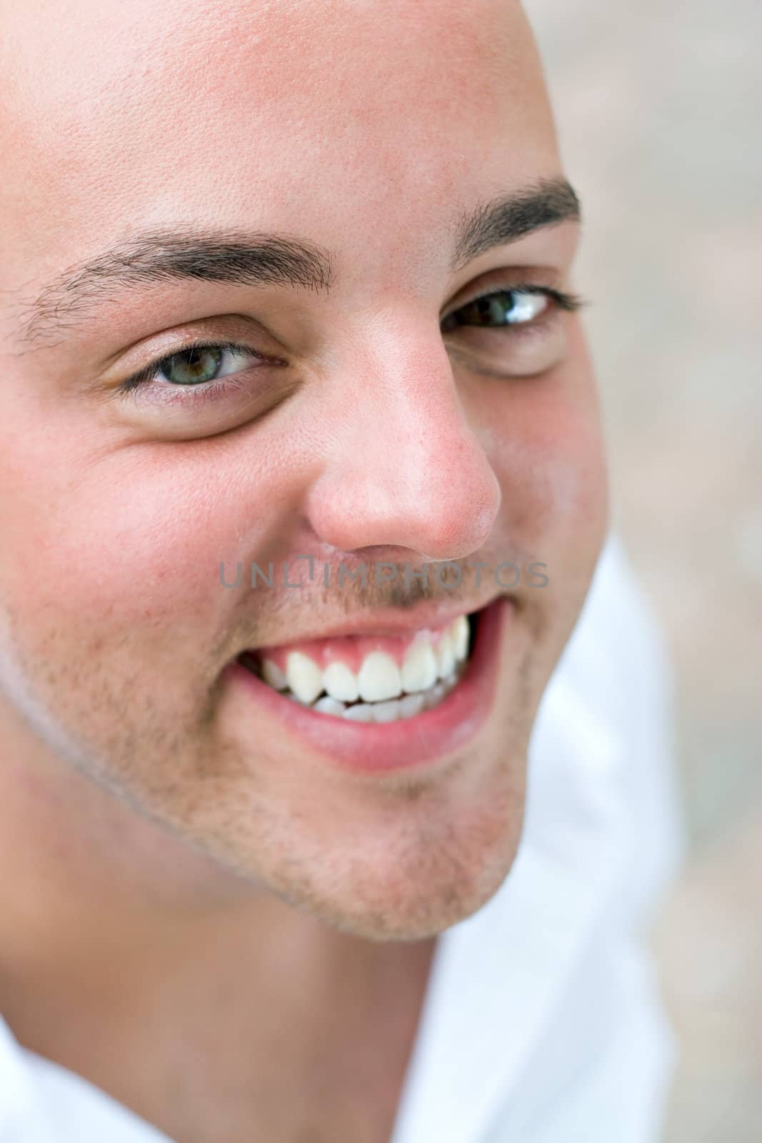 A smiling young bald man up close.  Shallow depth of field.