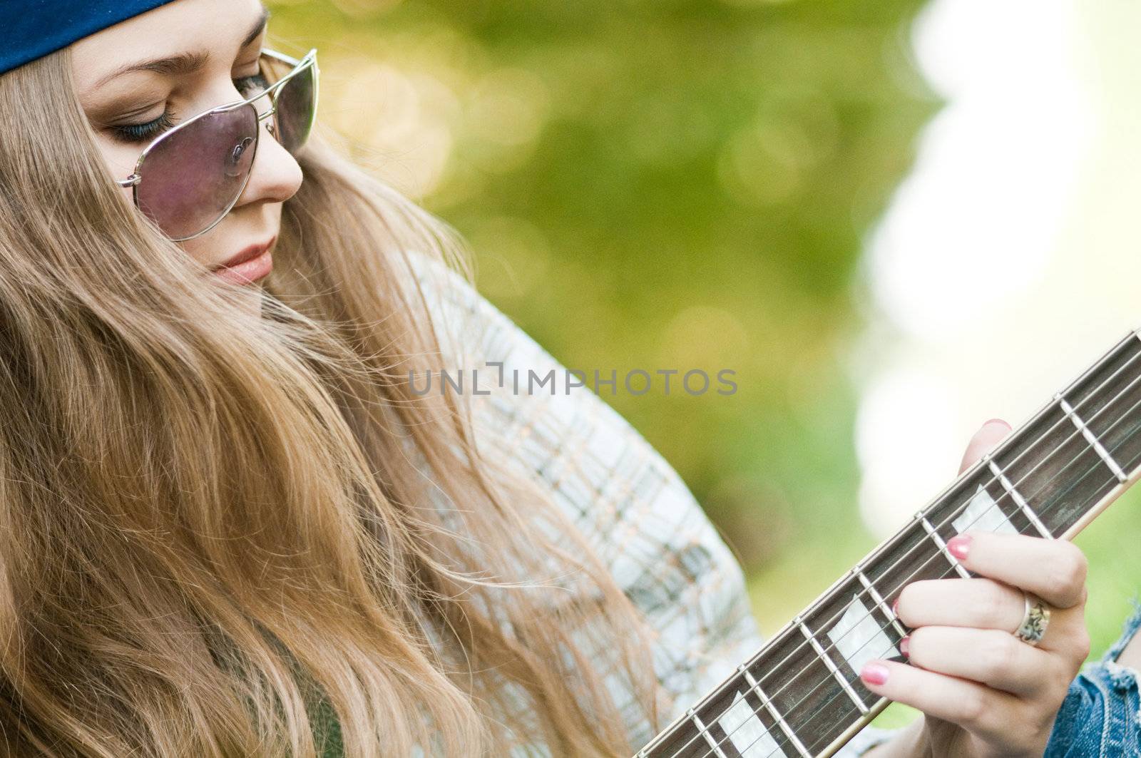 Rocking girl on a nature with guitar
