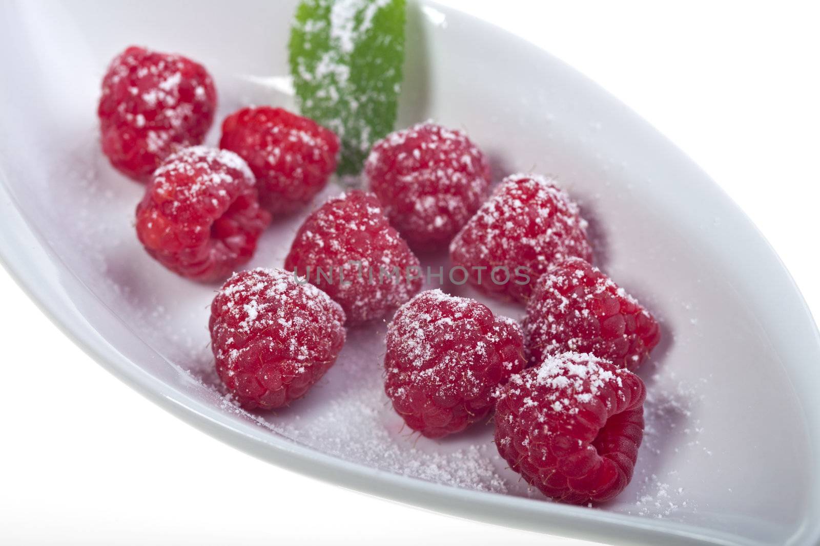 raspberries with icing sugar on a plate by bernjuer