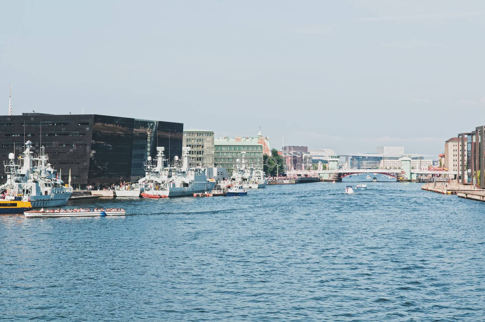 City river with docked battleships and bridge