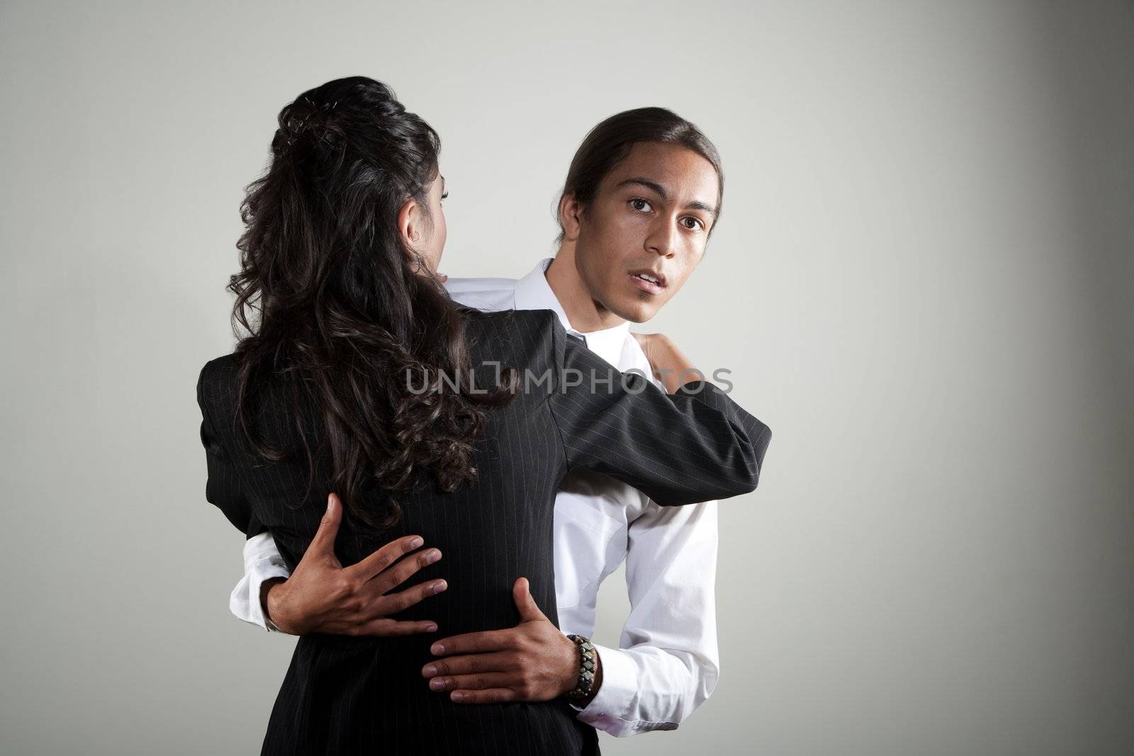 Handsome mixed race man embracing pretty Hispanic coworker
