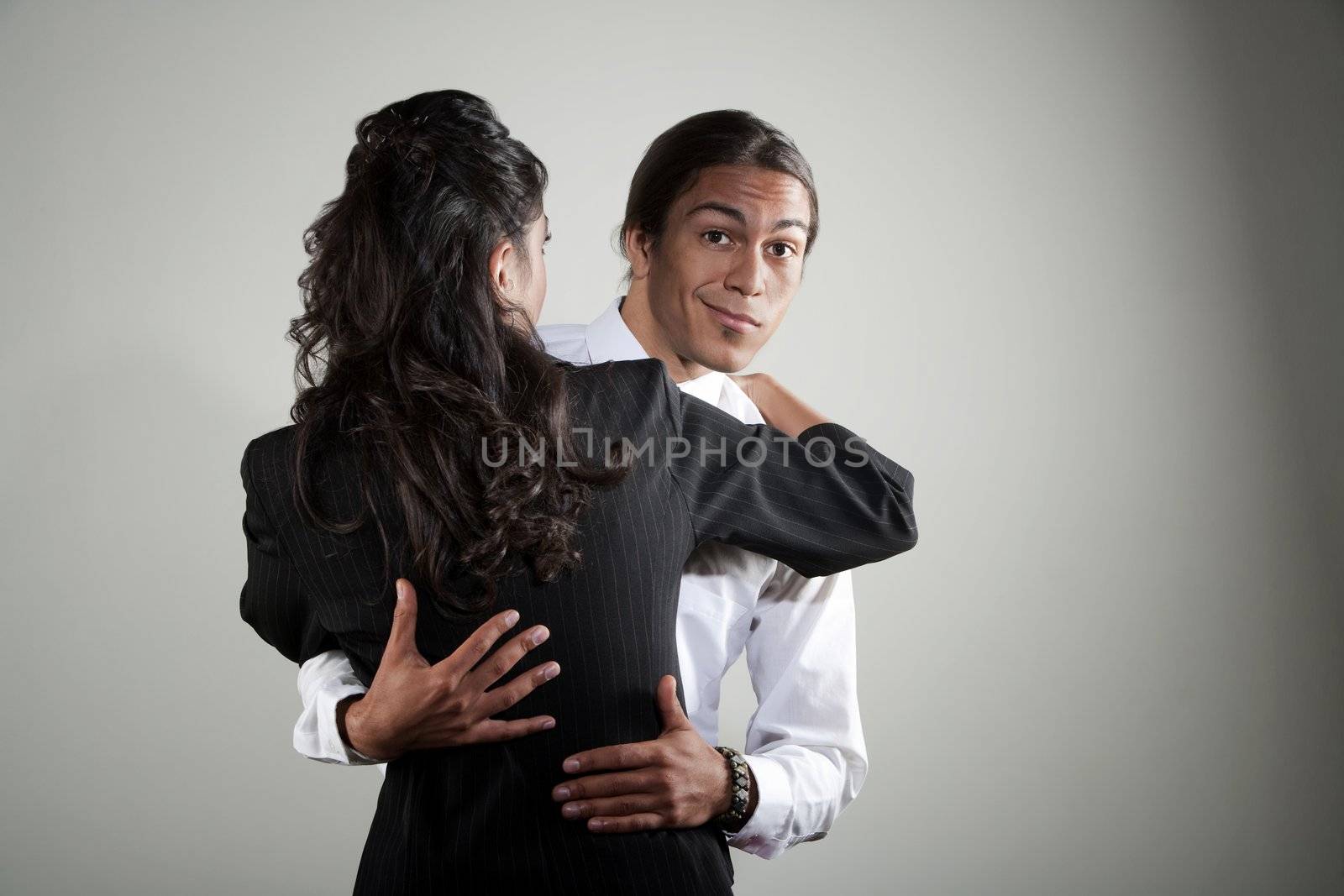 Mixed race professional man embracing Hispanic woman by Creatista