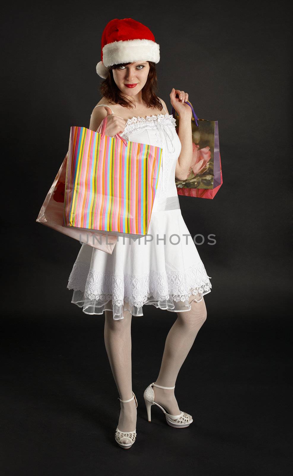 Beautiful girl in Christmas cap with gifts in hands by pzaxe