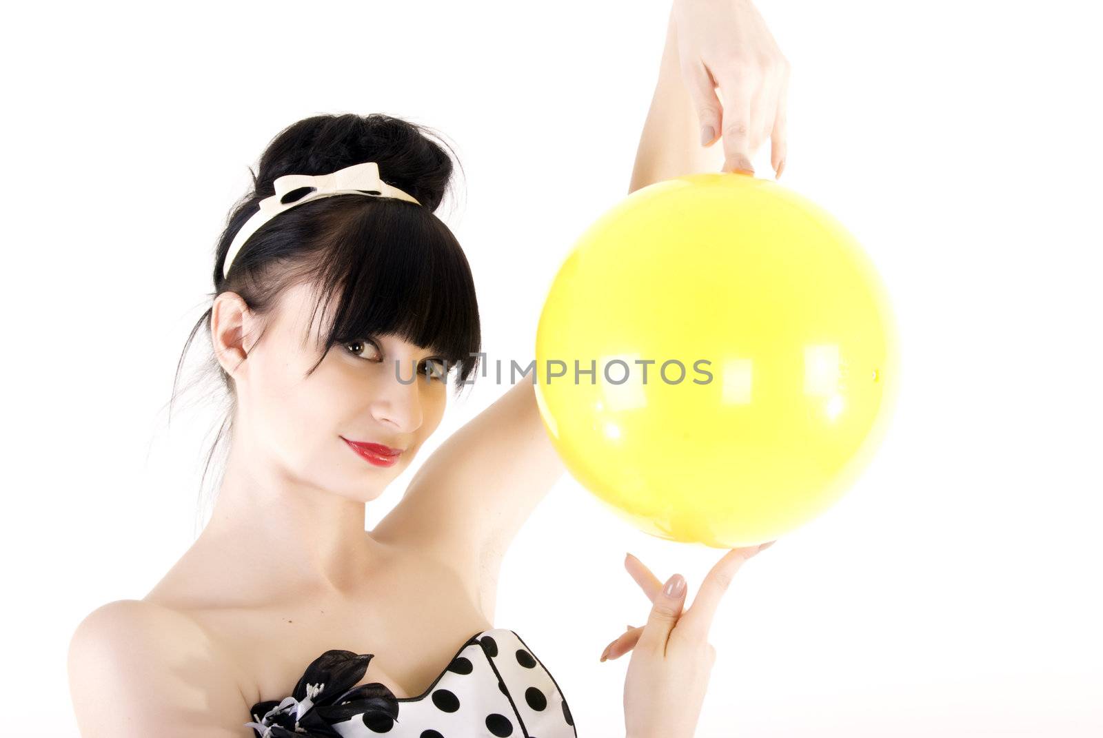 Portrait of a young beautiful brunette posing with yellow ball