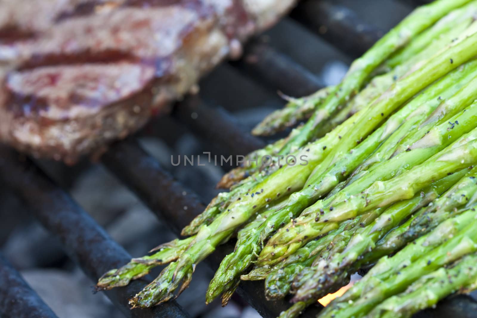 steak and asparagus on a charcoal grill short focus