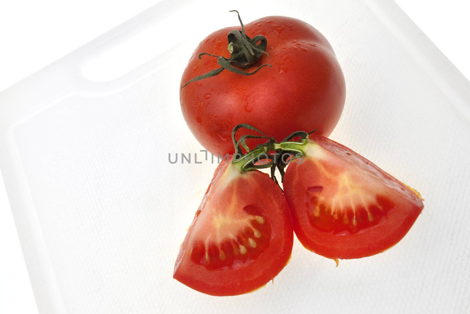 Cutting white plastic board with red tomato isolated on a white background.