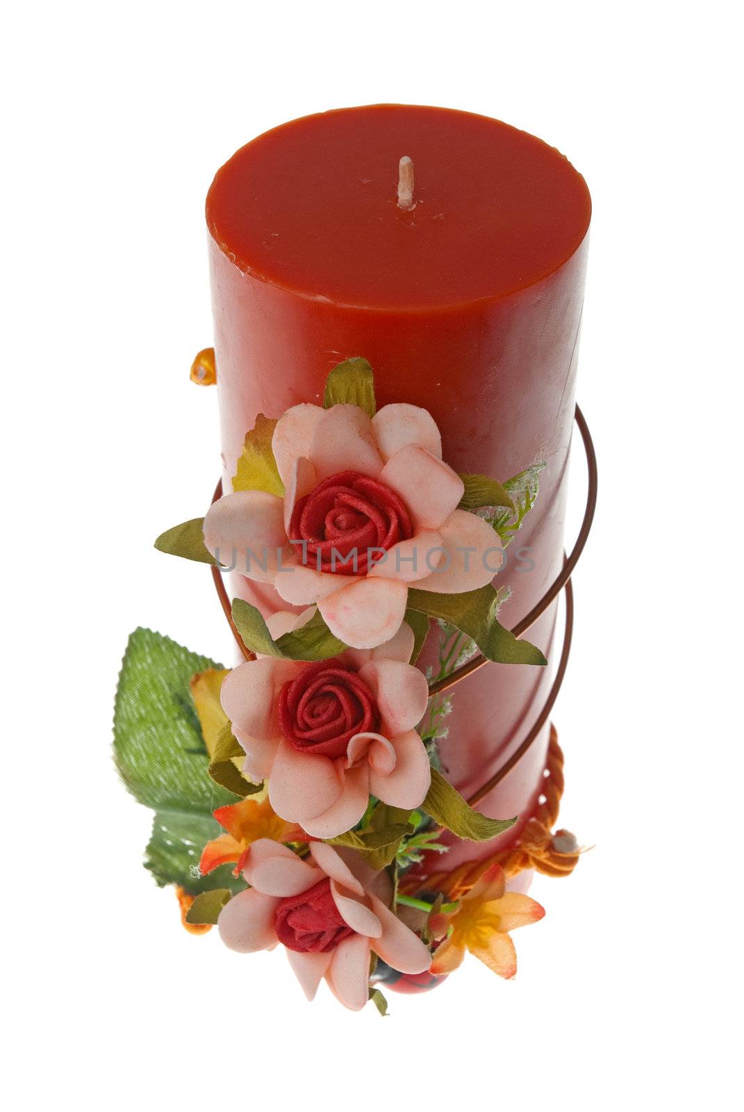 Large red candle with the flower decoration isolated on white background.