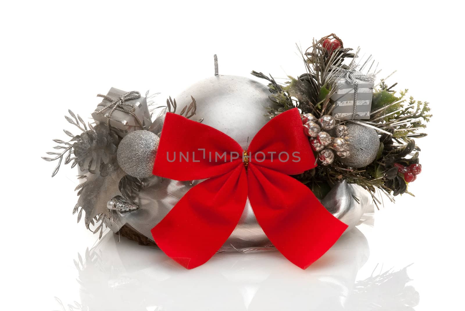Silver candle with red lace and christmas decorations on white background.