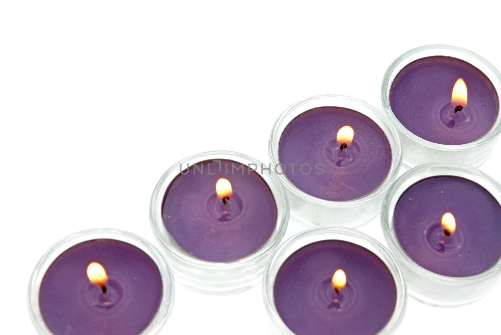 Purple candles in glass isolated on white background.