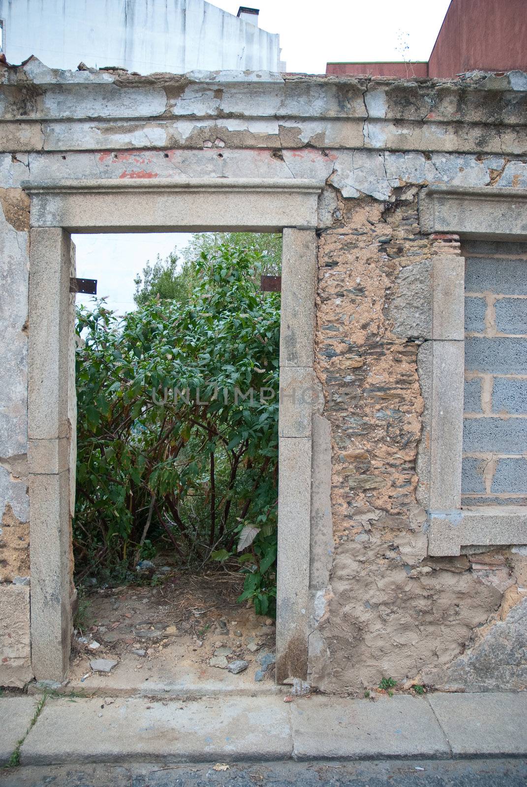 Old house facade with broken door and windows.