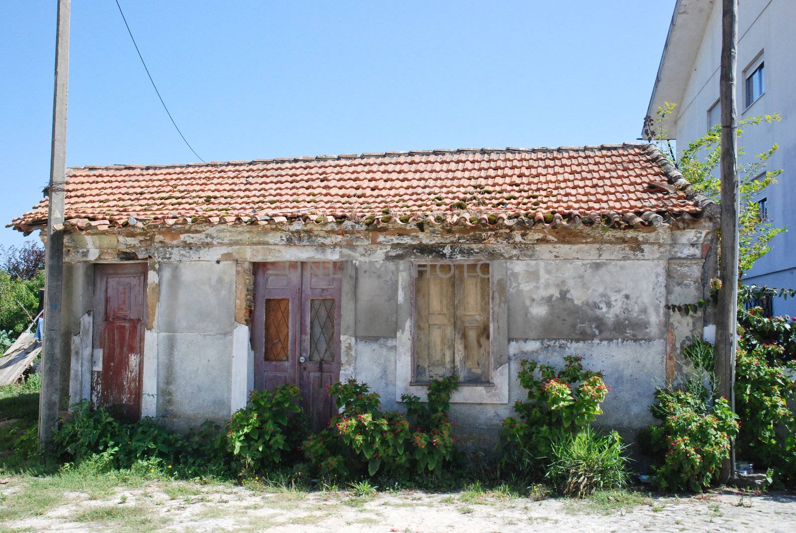 Old house facade with broken door and windows.