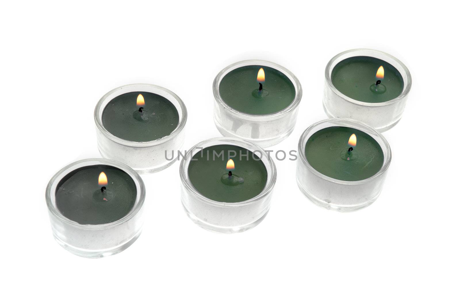 Green candles in glass isolated on white background.