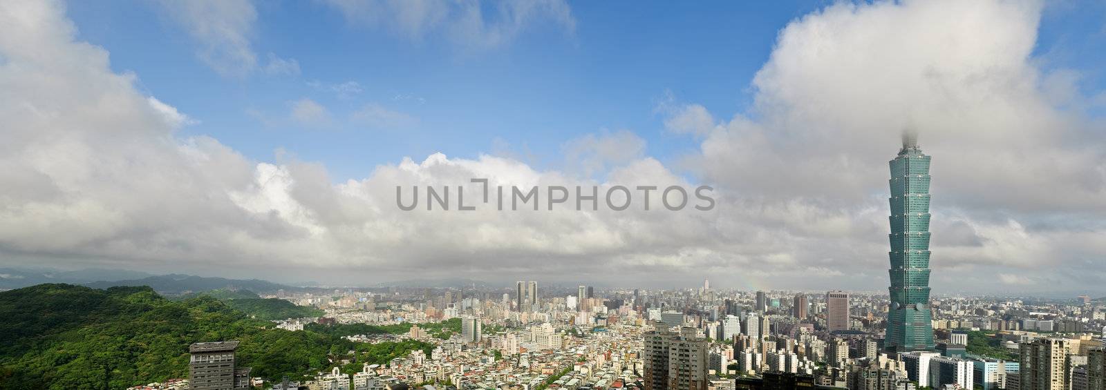 Taipei city skyline with famous 101 skyscraper building under white clouds and blue sky in Taiwan. Horizontal panoramic cityscape.