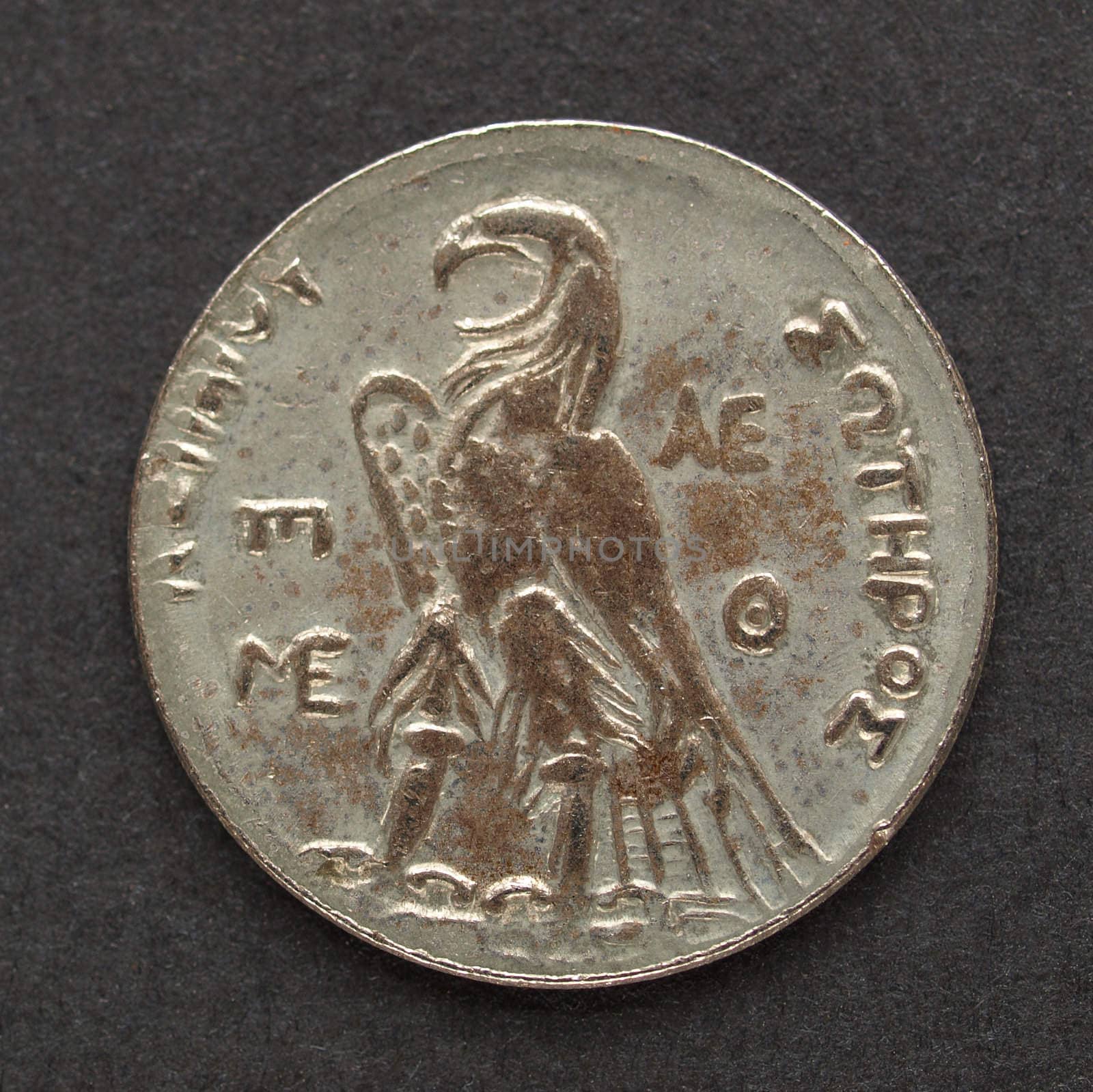 Ancient Greek coin on a black background