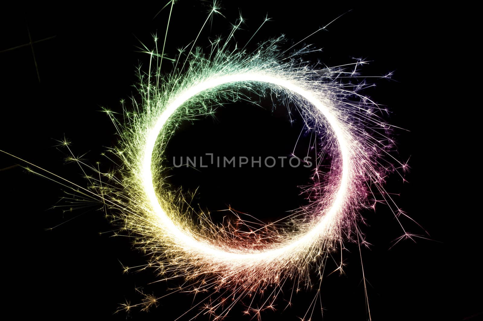 bright multi colored circle of glowing sparks on a black background