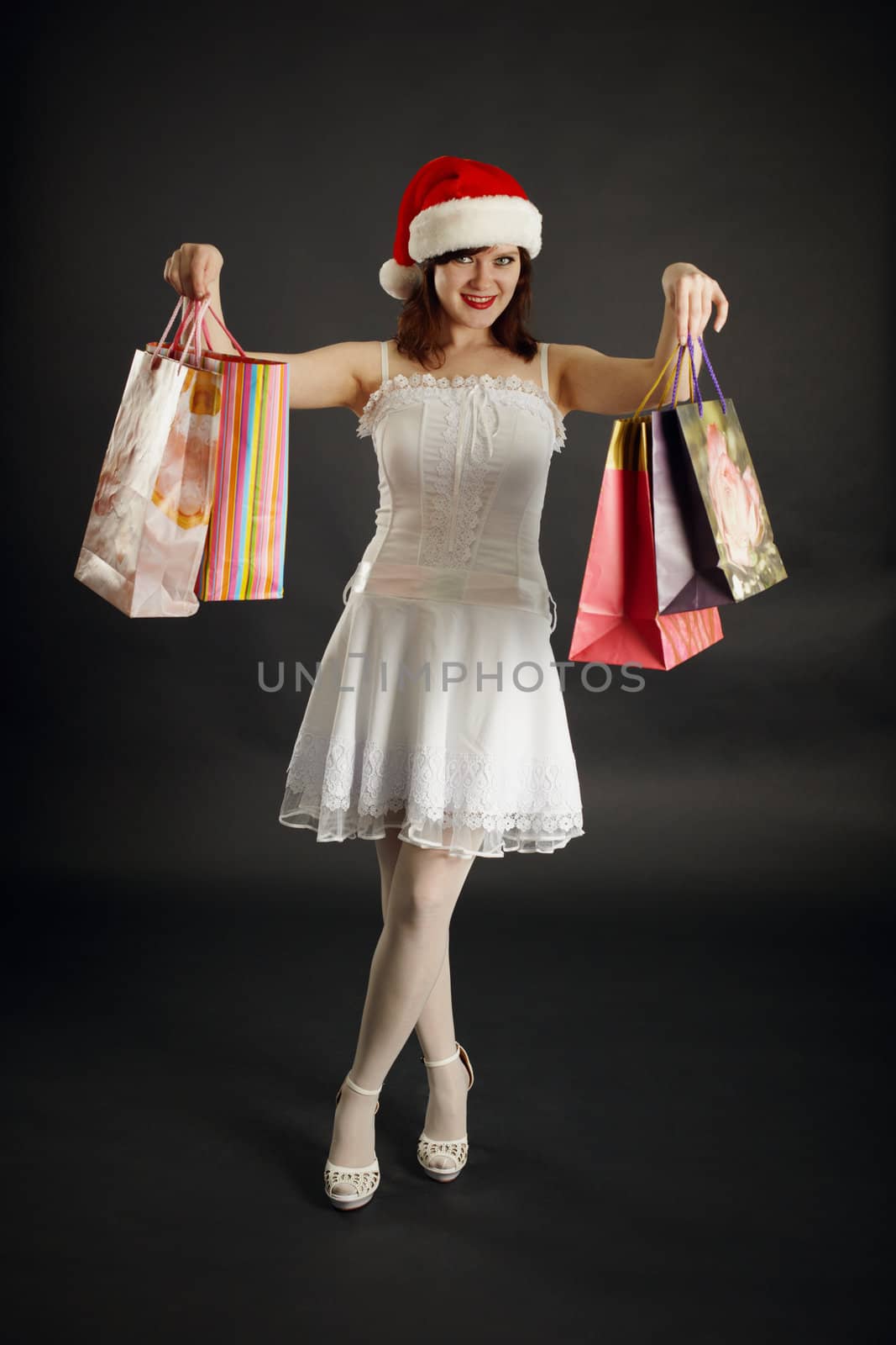 The woman rejoices to Christmas purchases against a dark background