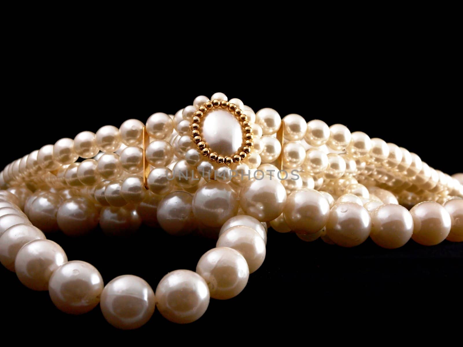 Pearls with brooch, high depth of field, towards black background