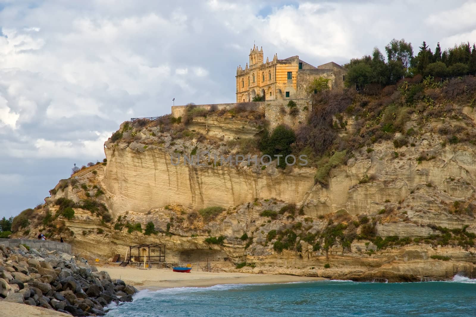 Shot taken in Tropea, Calabria, Italy. Church on rocks with sea and boat on beach.