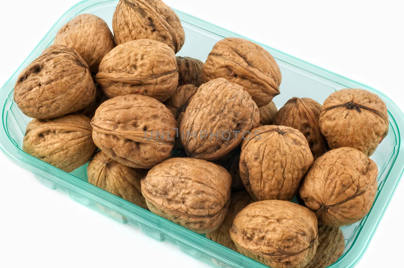 Walnuts in plastic container isolated on white