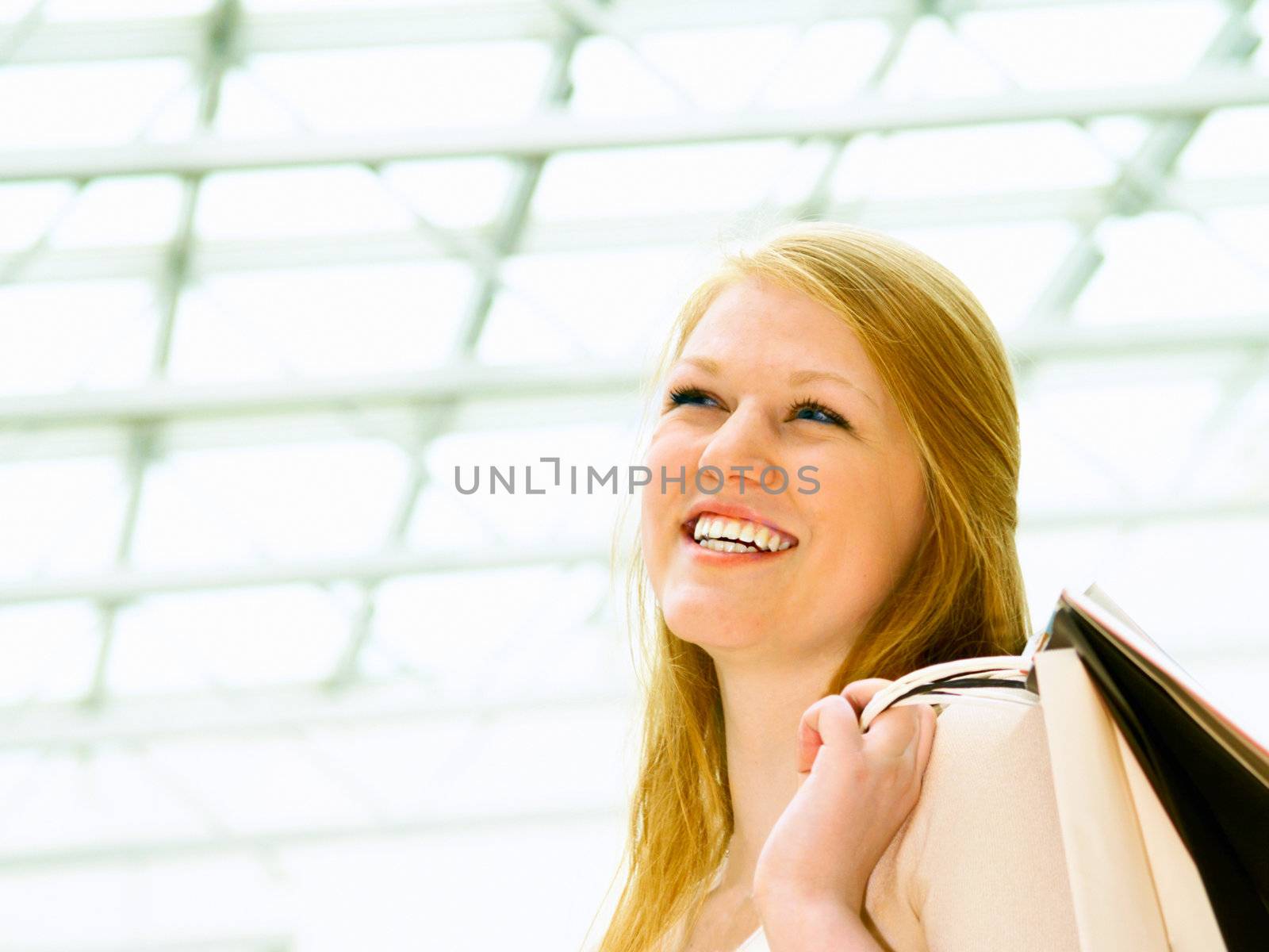Laughing happy young female holding shopping bags with copy space
