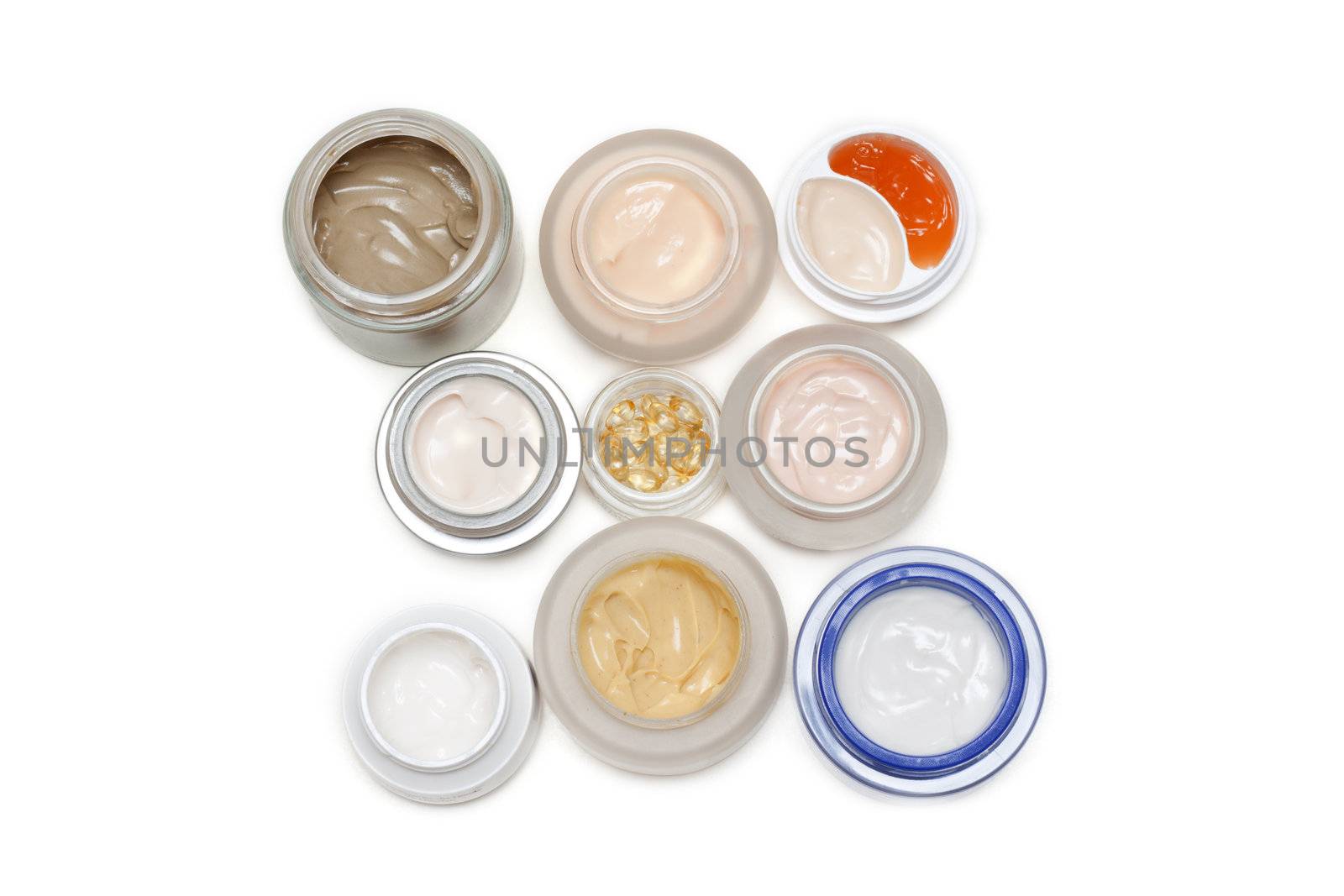 Opened banks with make-up cream on white background