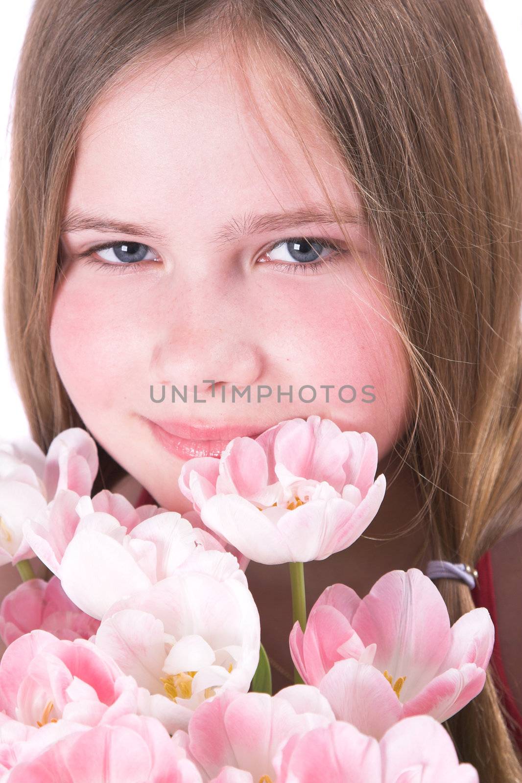 Pretty ten year old girl behind a bunch of pink tulips