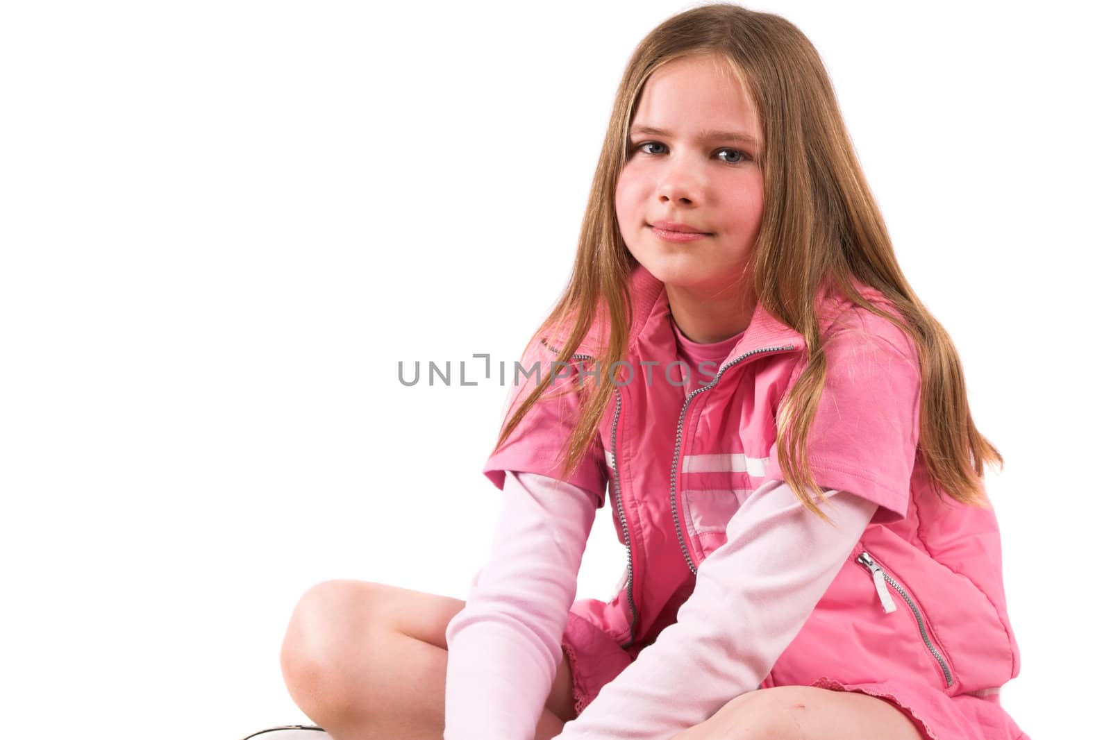 Pretty smiling ten year old girl sitting crosslegged on the couch