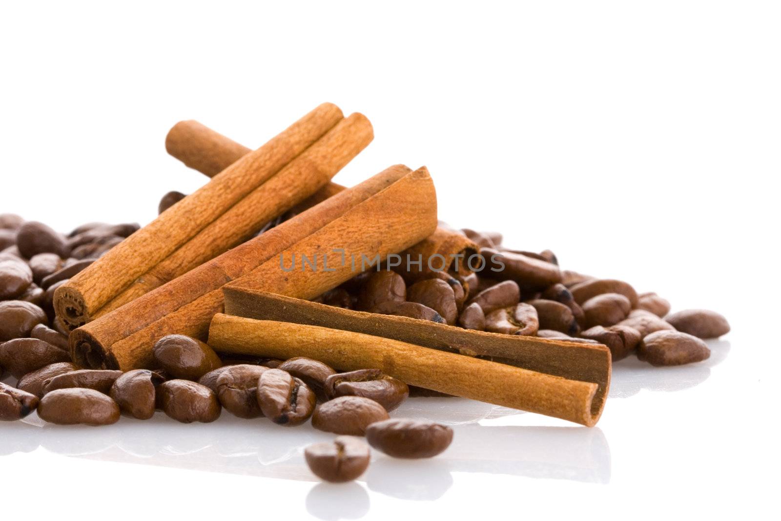 Cinnamon sticks and coffee beans on isolated background