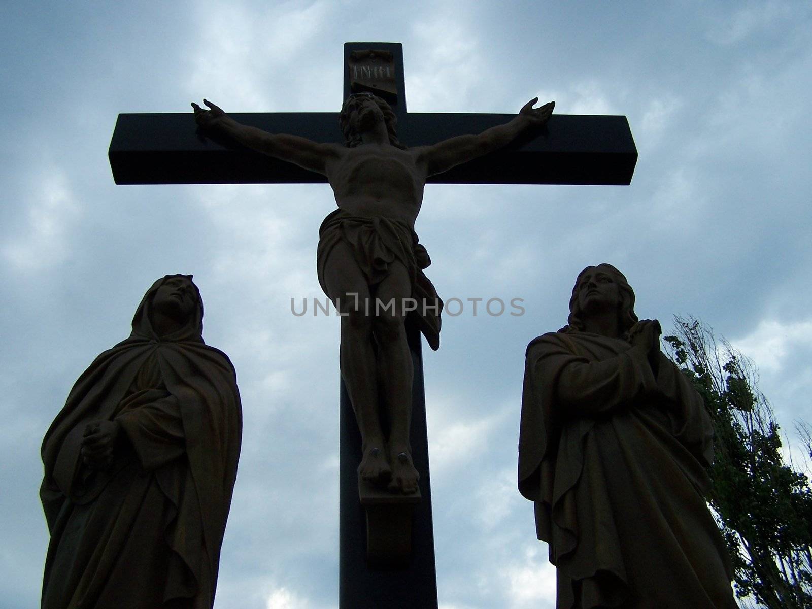 Christ hanging from the cross at sunset taken in a graveyard