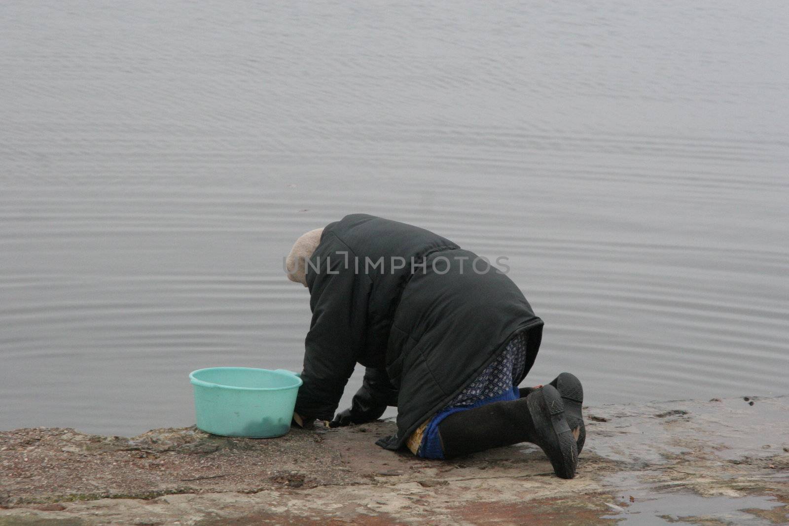 The old woman erases linen on the river by iar