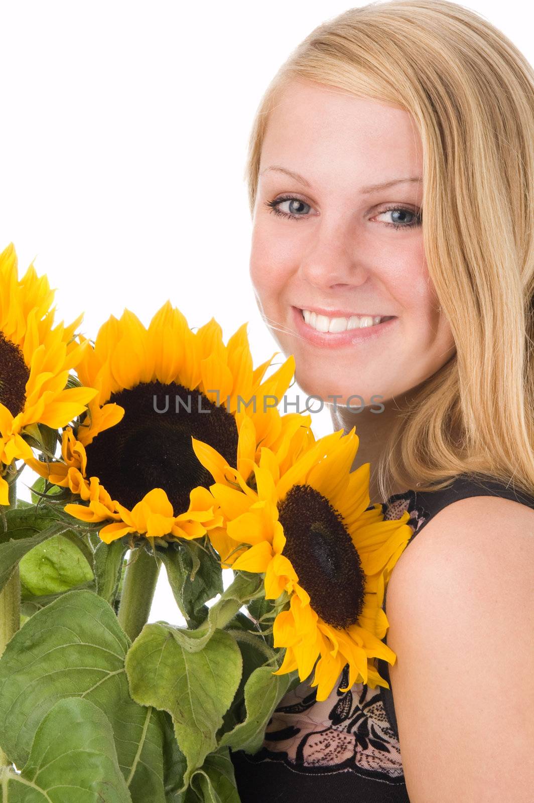 The attractive blonde in studio holds a sunflower in hands.