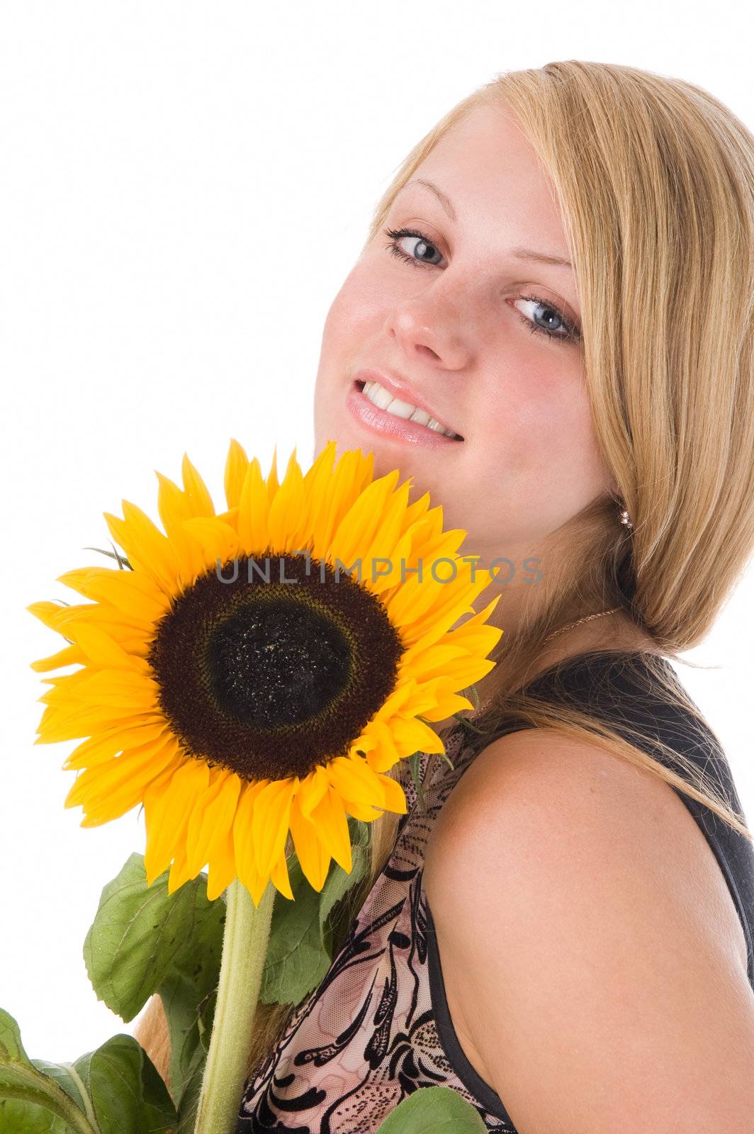 The attractive blonde in studio holds a sunflower in hands