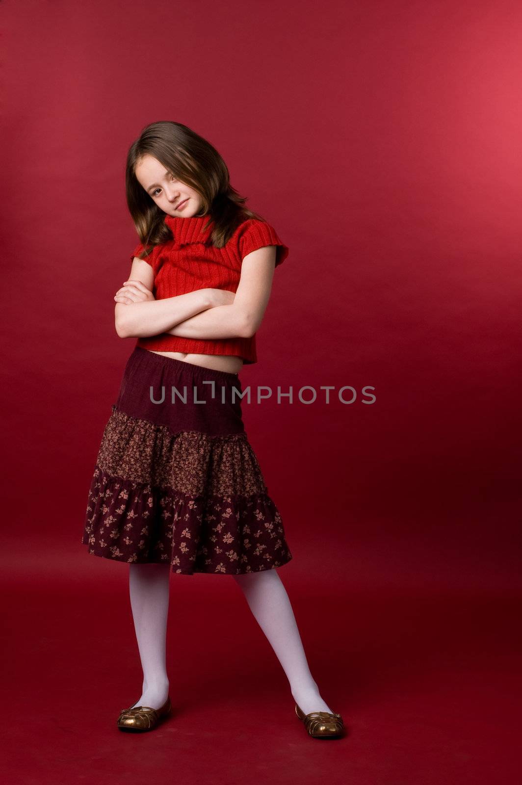 The girl of ten years in a red sweater in studio