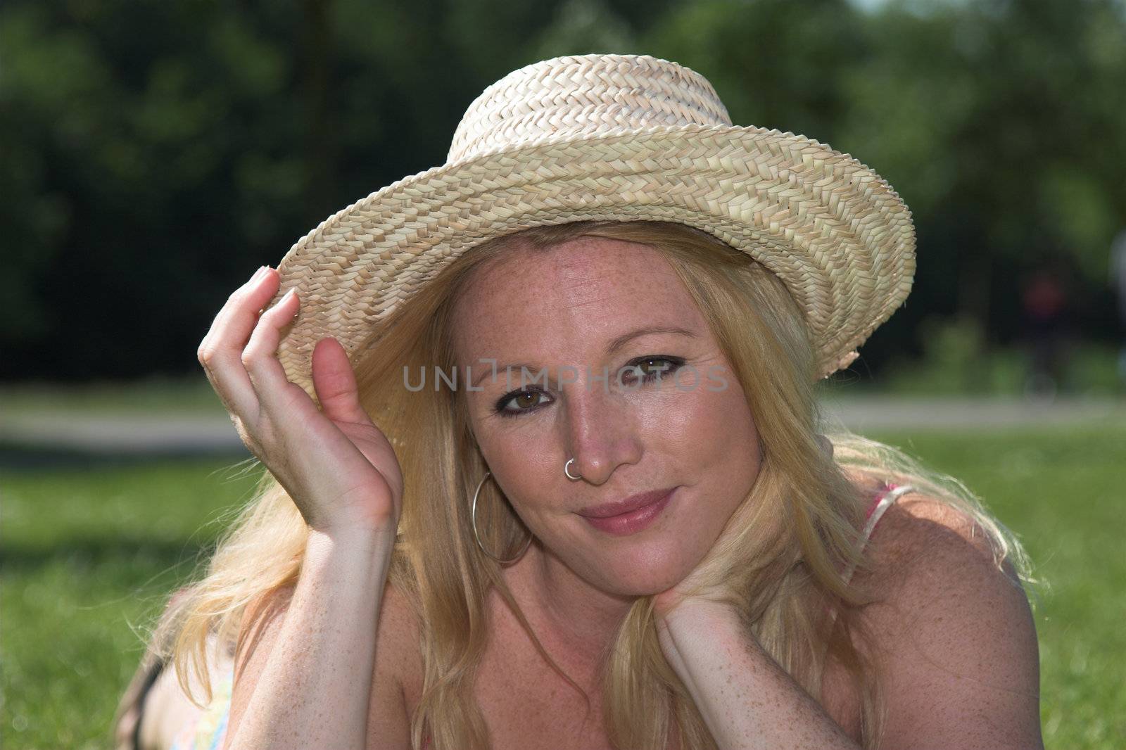 Beautiful blond woman relaxing in the park on a summer afternoon