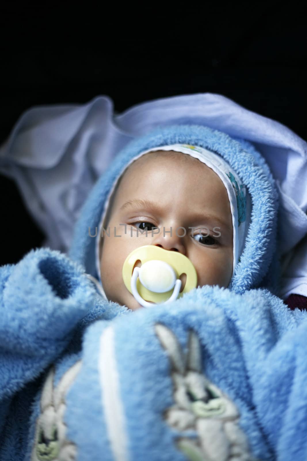 The young child in a blue suit on a dark background