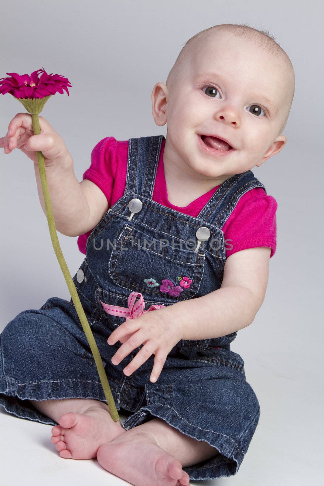 Beautiful baby girl holding flower