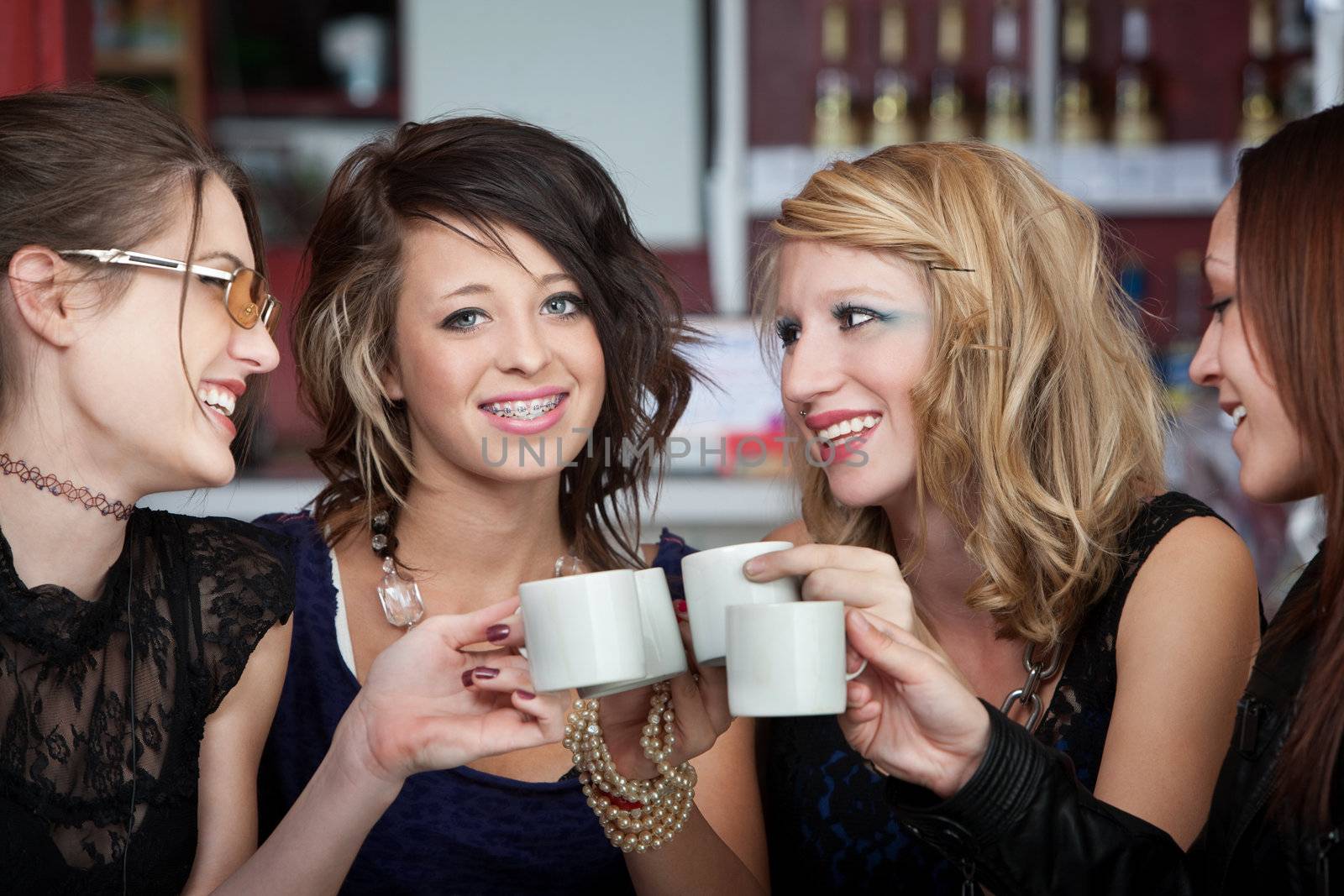 Joyful young teens having a good time over coffee