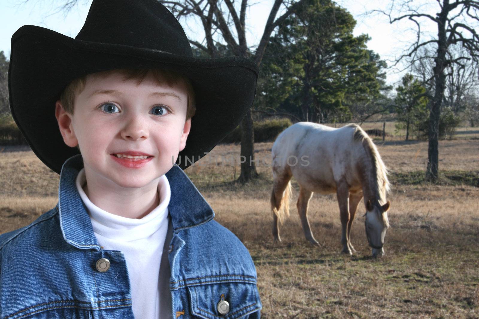Adorable four year old  in denim jacket and black cowboy hat.  Shot with the Canon 20D.