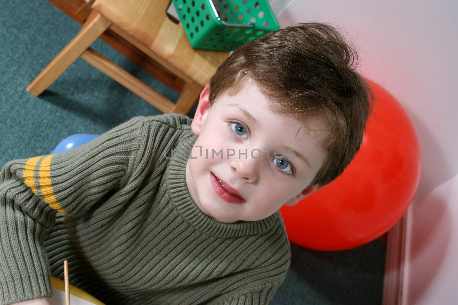 Handsome and happy little boy sitting in a pre-school.  Shot with the Canon 20D.
