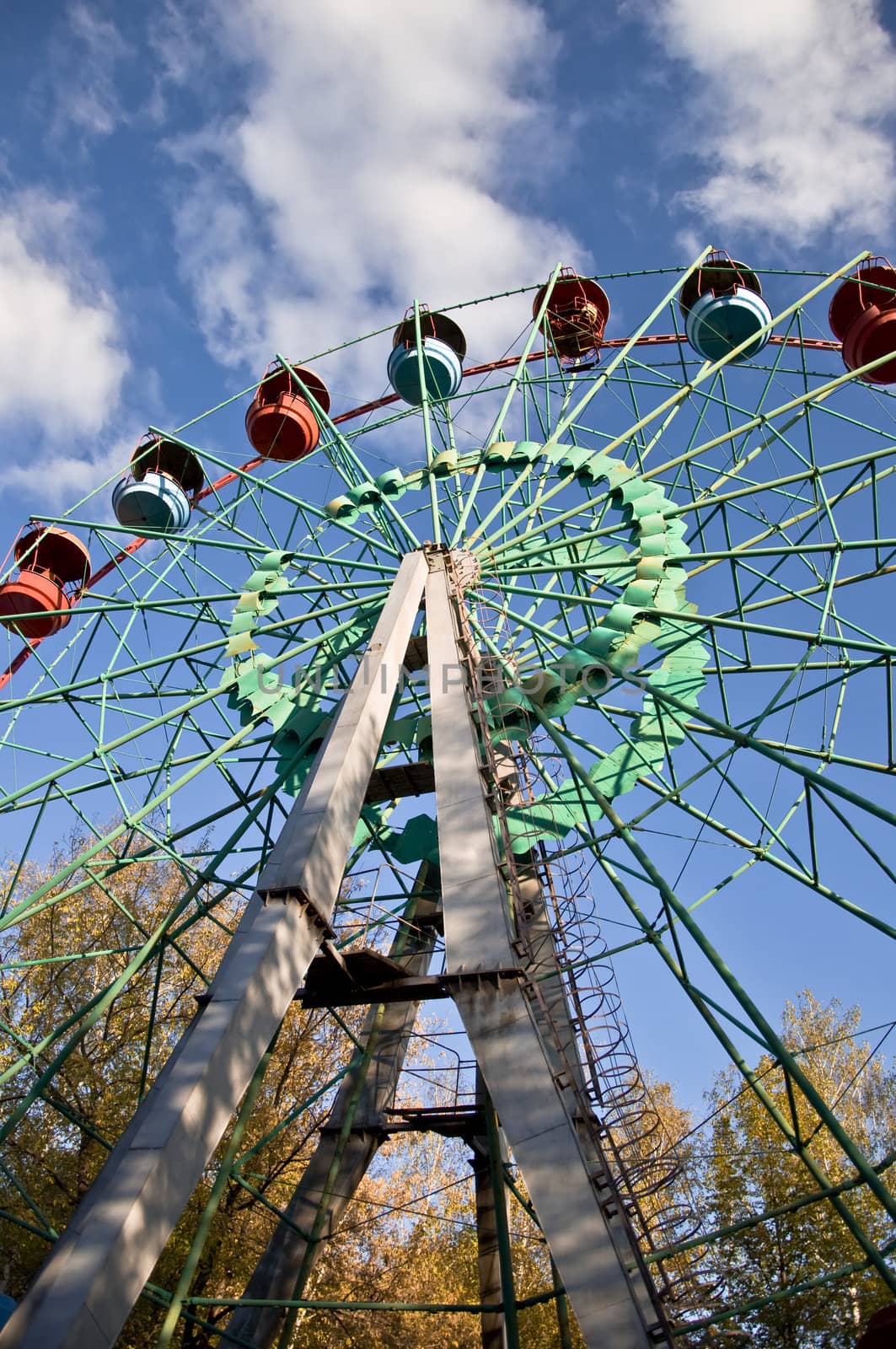 Ferris wheel in an amusement park. Autumn. Against the blue sky.