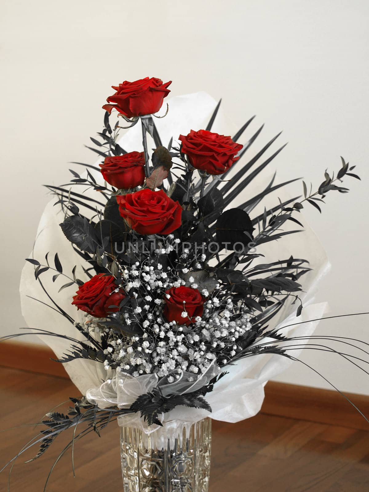 A bouquet of red roses over a desaturated black and white background