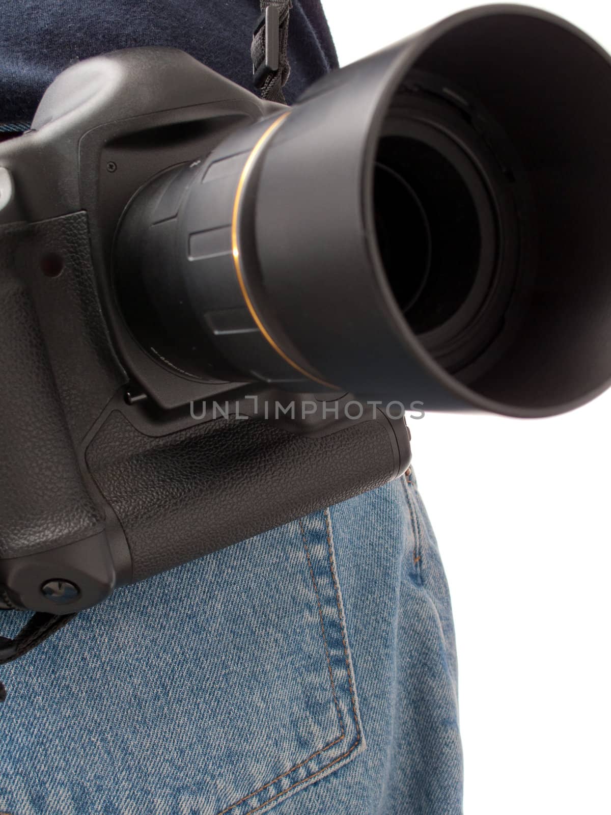 Focus on a digital SLR camera with lens and hood connected, hanging off the back, with the back pocket of denim jeans visible, isolated on white.