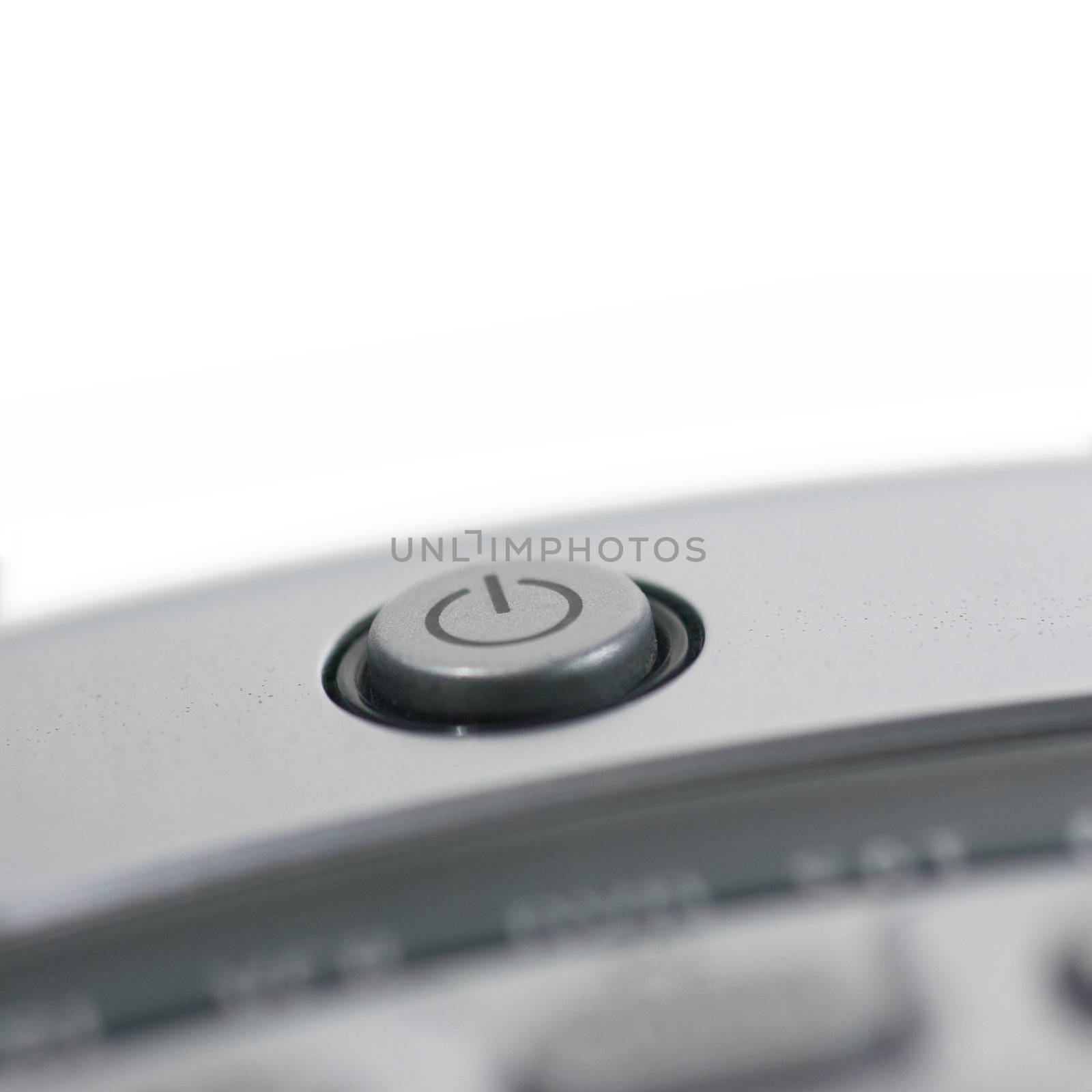 Closeup of a tv remote control, focus on the power button.