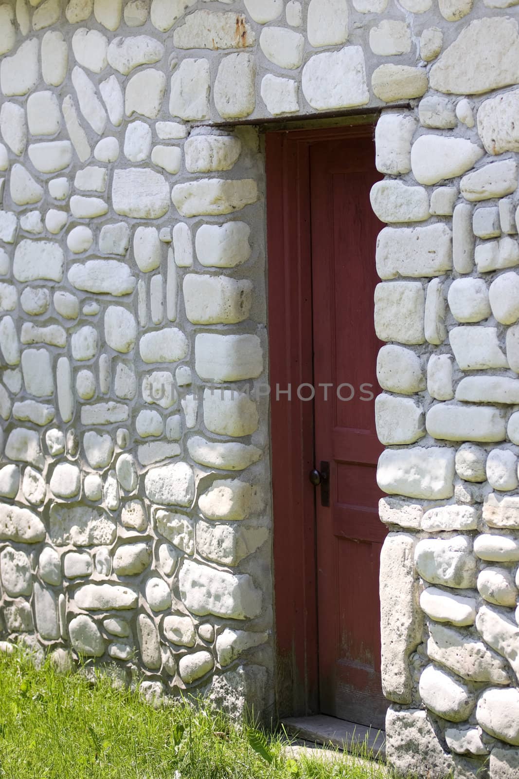 An old door set within a rock wall made up of shore stone from the local rock beaches.  Bruce Peninsula, Ontario, Canada